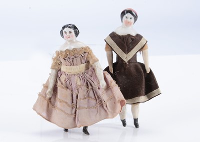 Lot 675 - Two late 19th century china shoulder-head dolls’ house dolls