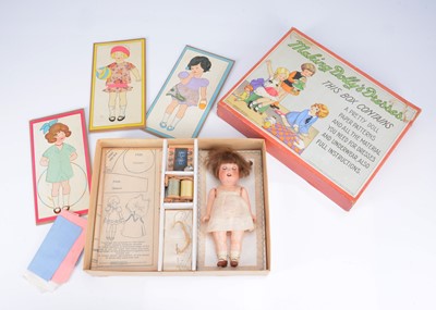 Lot 848 - A Spear’s ‘Making Dolly’s Dresses’ with Ernst Heubach bisque headed toddler
