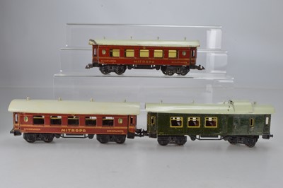 Lot 803 - Bing O Gauge continental 2 x  dining car and sleeping car in red with gold lining, No 10571 and 10572, together with a green passenger  / luggage coach, No 105, (3)