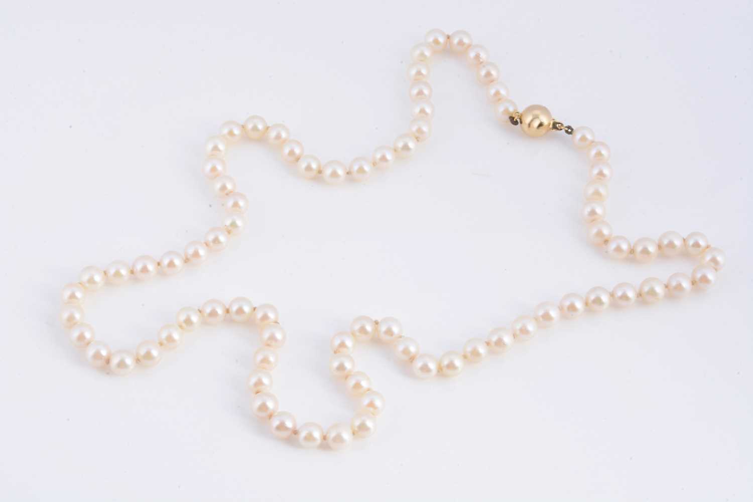 Lot 15 - A uniform knotted cultured pearl necklace, with 18k gold clasp