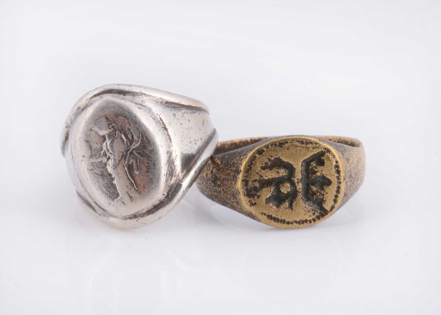 Lot 79 - A white metal signet ring & a brass example