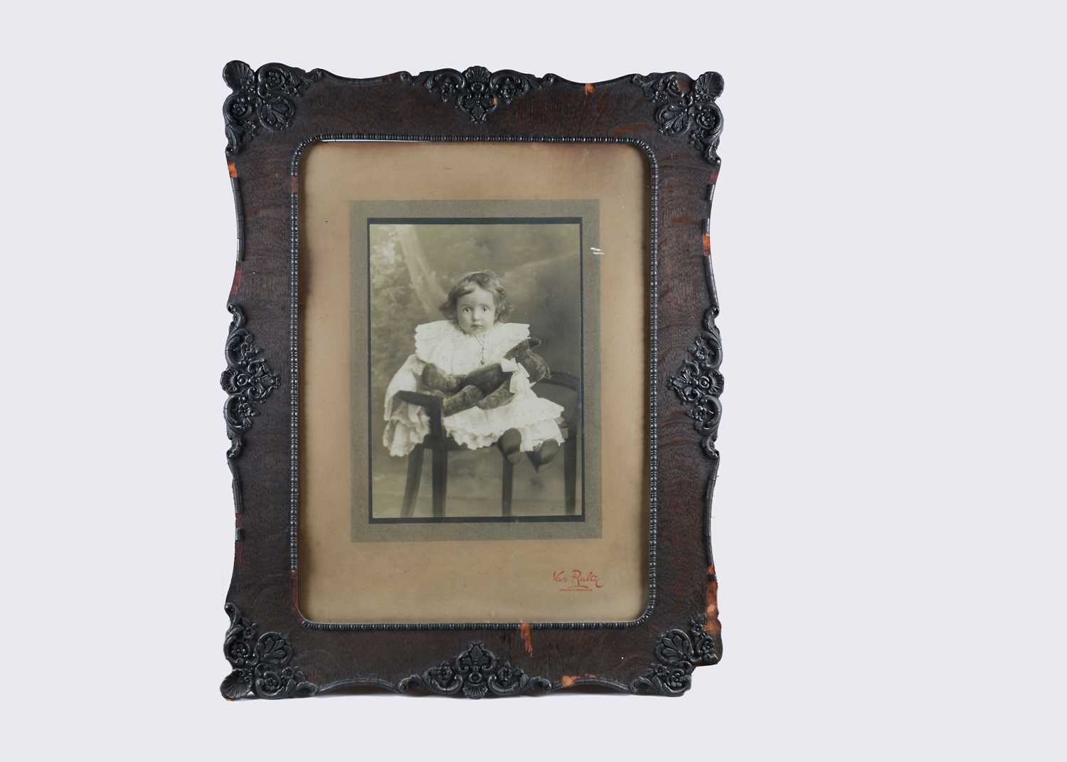 Lot 70 - A very large studio photograph of a young child holding a teddy bear, circa 1910