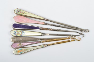 Lot 534 - A collection of seven guilloche enamel handled button hooks