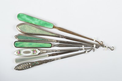 Lot 535 - A collection of seven guilloche enamel and shagreen handled button hooks