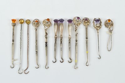Lot 551 - A collection of silver and silver handled small button hooks