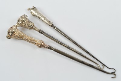 Lot 552 - Two novelty silver handled steel button hooks