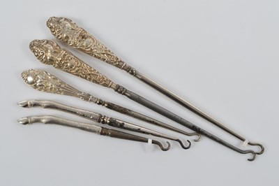 Lot 554 - Five novelty silver handled steel button hooks