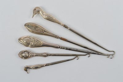Lot 555 - Five novelty silver handled steel button hooks