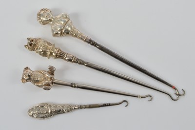 Lot 556 - Four novelty silver handled steel button hooks