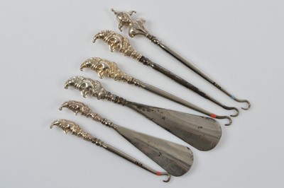 Lot 558 - Six novelty silver handled button hooks and shoe horns