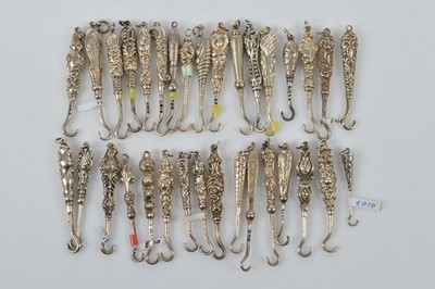 Lot 582 - A collection of small silver button or glove hooks