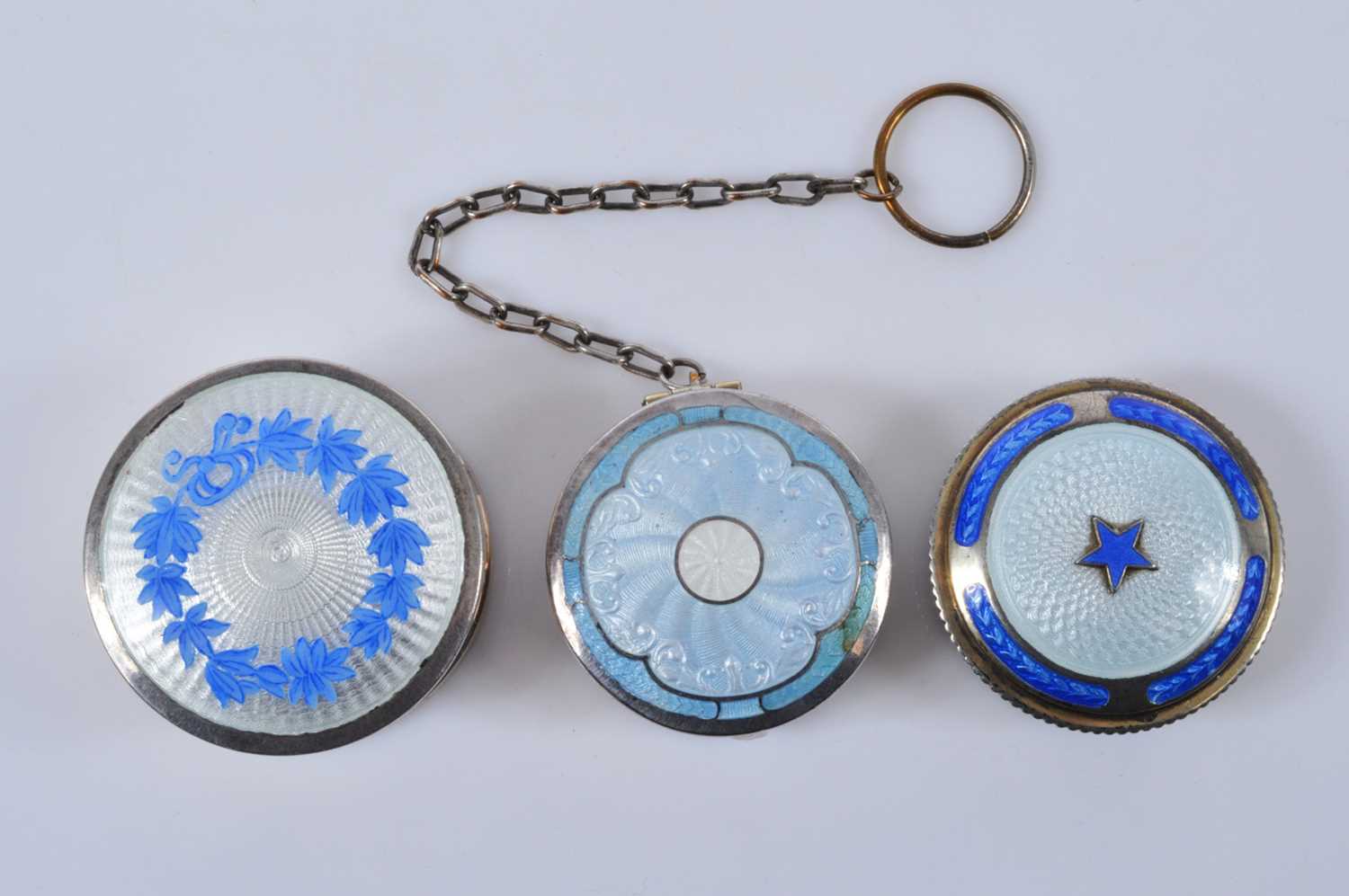 Lot 719 - Three circular silver blue guilloche enamel mounted compacts