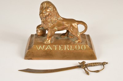 Lot 233 - A brass Lion of Waterloo Paperweight together with a Waterloo Souvenir Paperknife