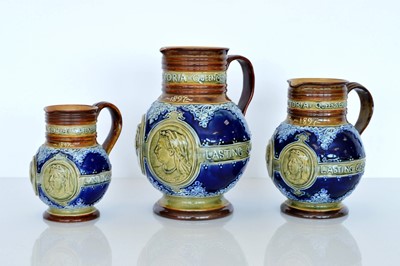 Lot 412 - A group of three graduated Doulton Lambeth Commemorative stoneware water jugs