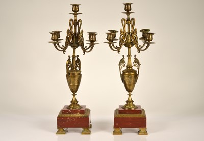 Lot 140 - A pair of brass and red marble four branch candelabra
