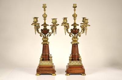 Lot 148 - A pair of large stained walnut and brass four branch candelabra