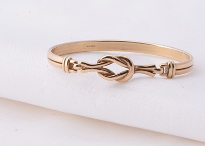 Lot 19 - A 9ct gold reef knot bangle