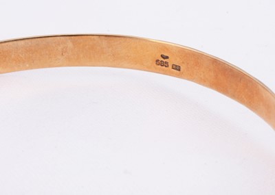 Lot 63 - A 14k gold bangle with engraved design