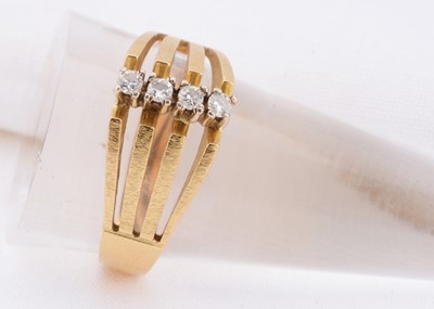 Lot 94 - A 18ct gold split band ring set with a row of four diamonds