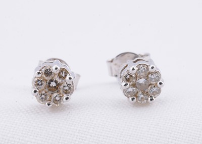 Lot 114 - A pair of 18ct white gold daisy cluster stud earrings