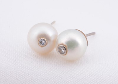 Lot 137 - A pair of cultured pearl studs with diamonds set in centre