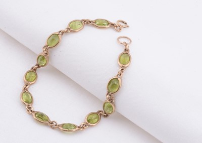 Lot 138 - A yellow metal bezel set multi peridot bracelet
