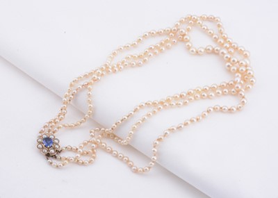 Lot 141 - A graduated triple row cultured pearl necklace with 9 ct gold clasp set with synthetic sapphire & pearls