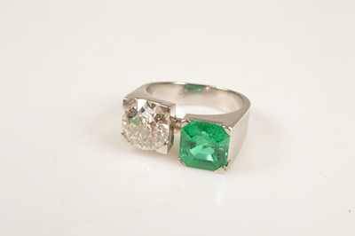 Lot 224 - A platinum diamond & emerald “Toi et moi” style dress ring