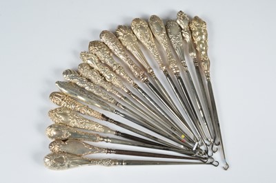 Lot 264 - A collection of seventeen silver handled button hooks