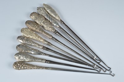 Lot 275 - A collection of nine silver handled button hooks