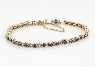 Lot 64 - A 9ct gold two colour sapphire and diamond tennis bracelet
