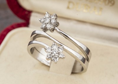 Lot 32 - A continental white metal 750 marked crossover dress ring