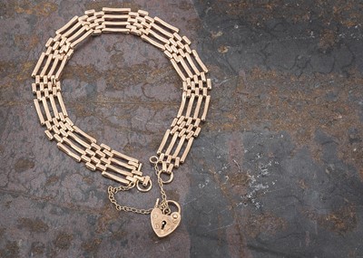 Lot 57 - A yellow metal gate link bracelet with heart shaped padlock clasp