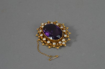 Lot 113 - An Edwardian 9ct marked yellow metal amethyst and seed pearl oval brooch