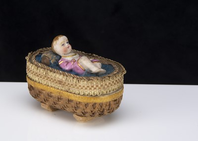 Lot 370 - A 19th century bisque baby lying in a cradle bon-bon box