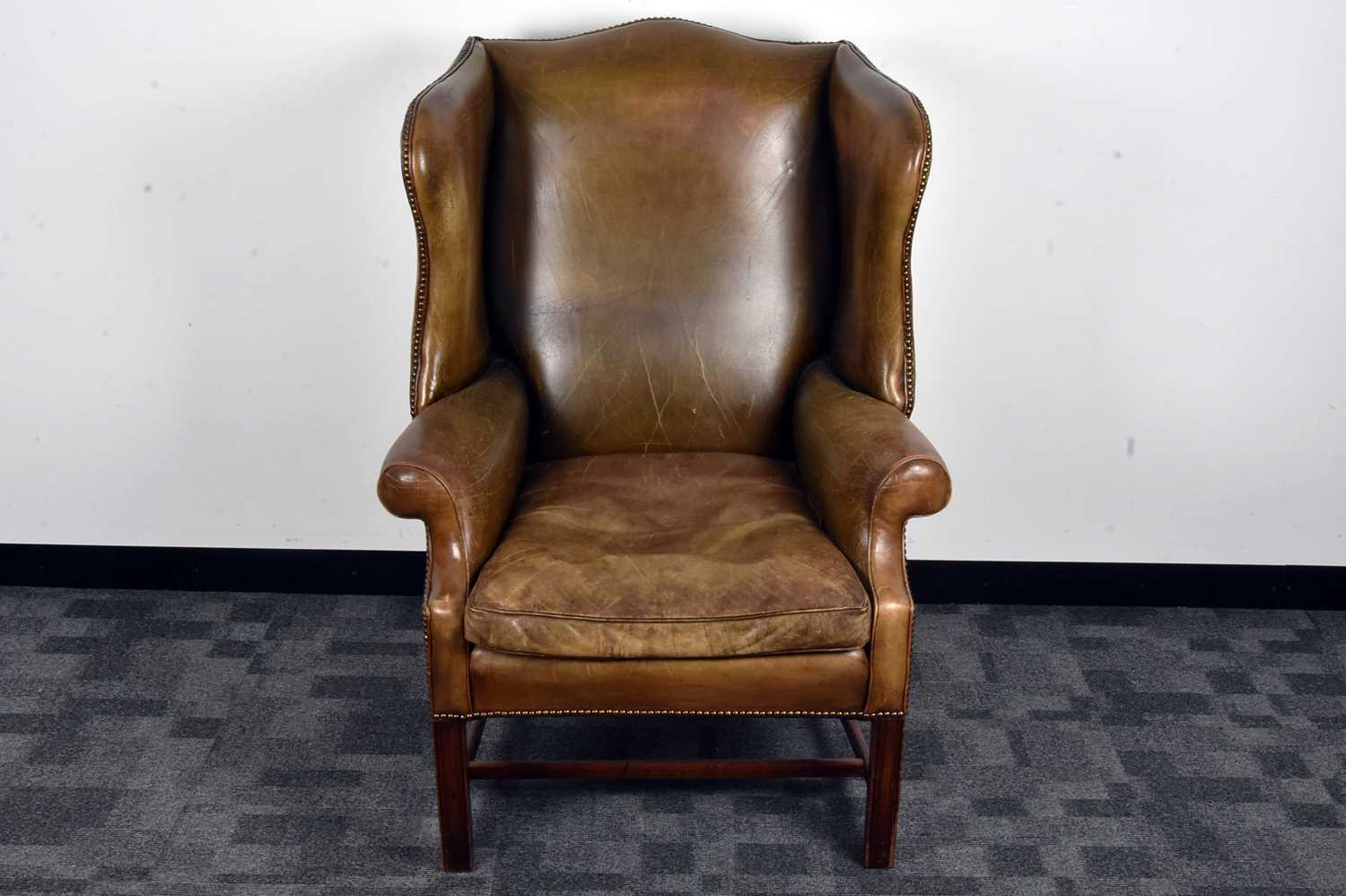 Lot 39 - A George III style leather wing back armchair