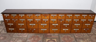Lot 99 - A Victorian period mahogany apothecary drawer unit, 246cm wide and 64cm high, with multiple drawers, most with glass applied sign and glass knobs, AF
