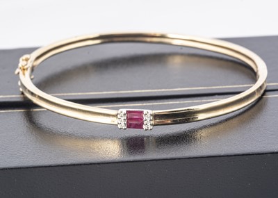Lot 214 - A 9ct gold ruby and diamond bangle