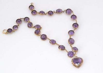 Lot 230 - An Edwardian amethyst and seed pearl heart shaped pendant and chain