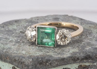 Lot 234 - A three stone emerald and diamond dress ring