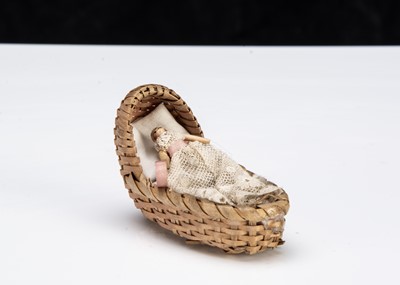 Lot 10 - A miniature Grodnerthal dolls’ house doll in cradle