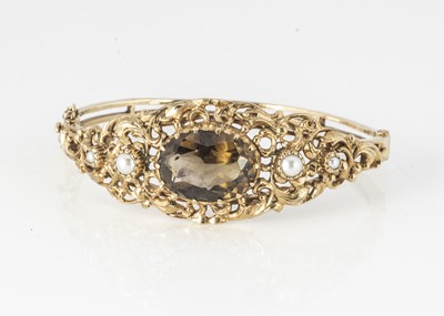 Lot 286 - A 9ct gold smoky quartz and half cut pearl bangle