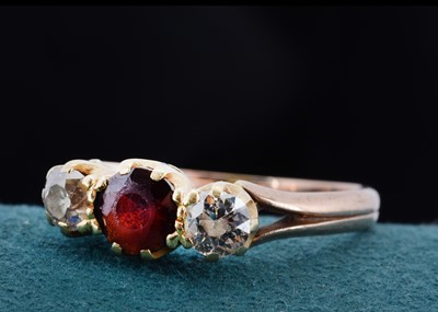 Lot 23 - An 9ct gold garnet and diamond three stone dress ring