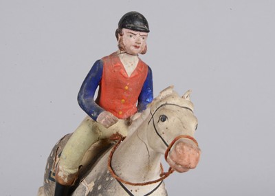 Lot 359 - A mid 19th century Thüringen composition jockey riding grey horse pull along toy