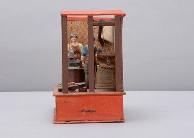 Lot 376 - A mid 19th century Thüringen papier-mâché and wood blacksmith’s forge mechanical toy