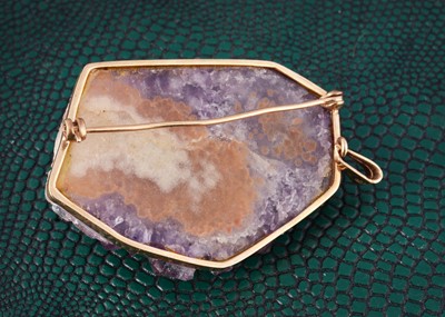 Lot 3 - A natural amethyst crystal framed in yellow metal