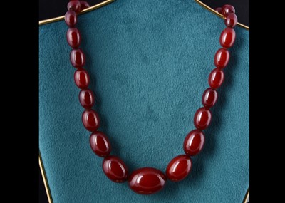 Lot 22 - A long string of 'cherry amber' beads