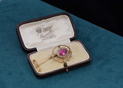 Lot 80 - An Edwardian seed pearl and synthetic ruby oval brooch, of pierced design