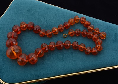 Lot 122 - A string of faceted graduated translucent amber beads