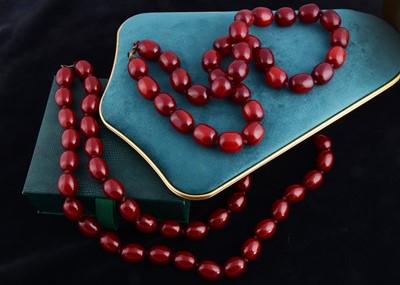 Lot 207 - Two large strings of 'cherry amber' beads